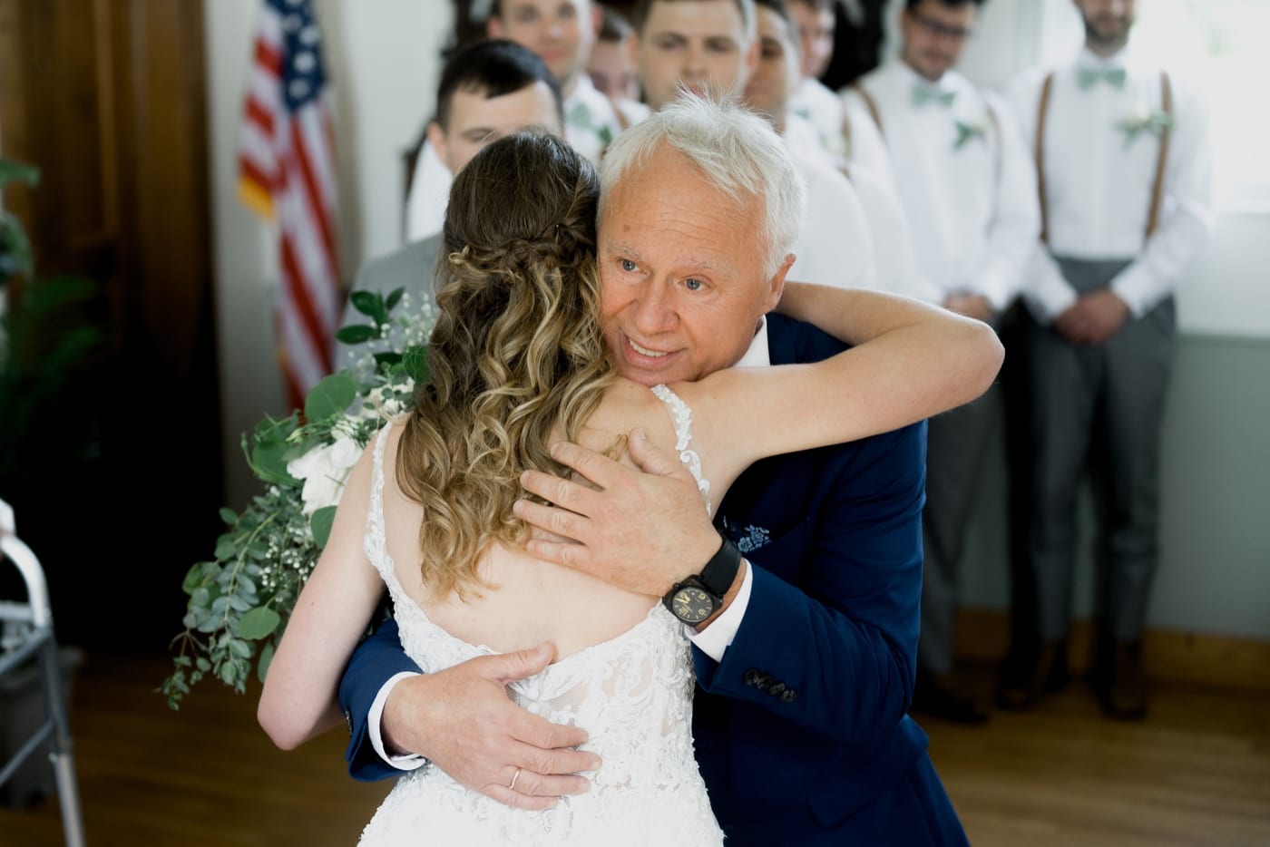 father hugging bride at the end of the aisle