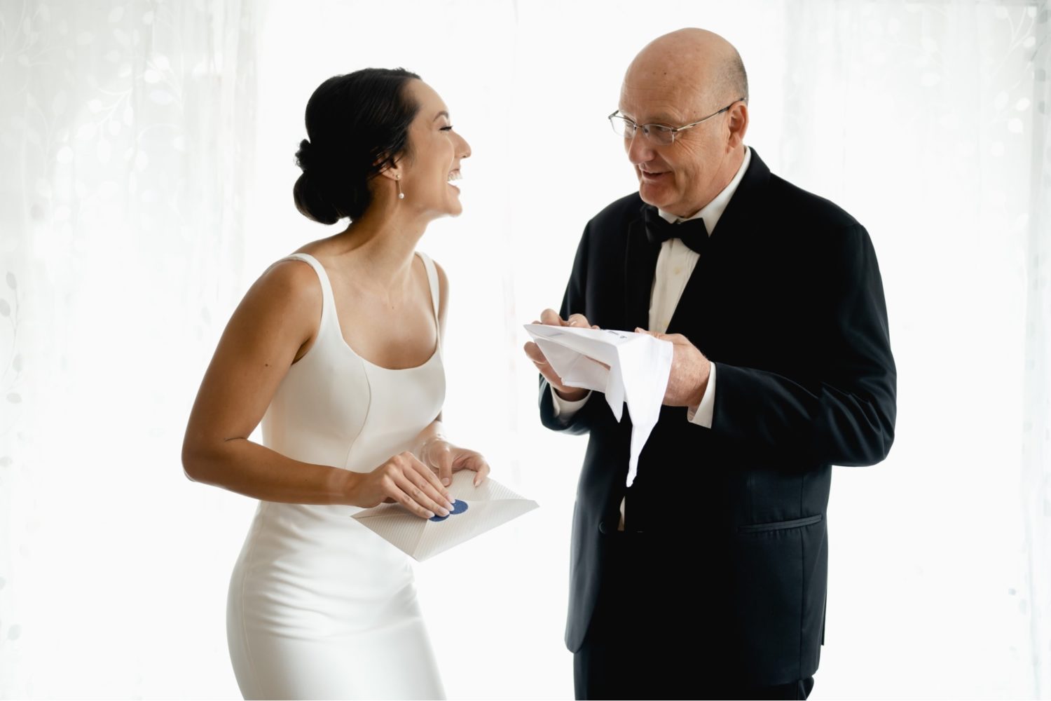 Bride and her father laughing during their first look