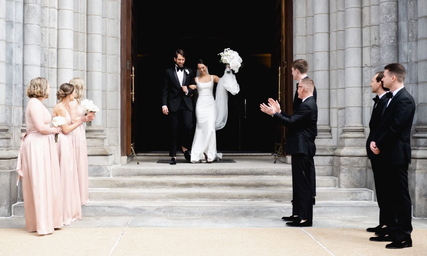 Bride and groom walking out the doors of the cathedral basilica of St. Louis