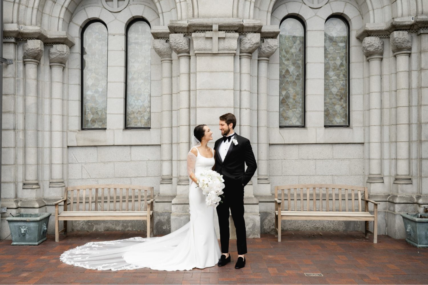 Bride and groom smiling at each other in the courtyard of the Cathedral Basilica of St. Louis