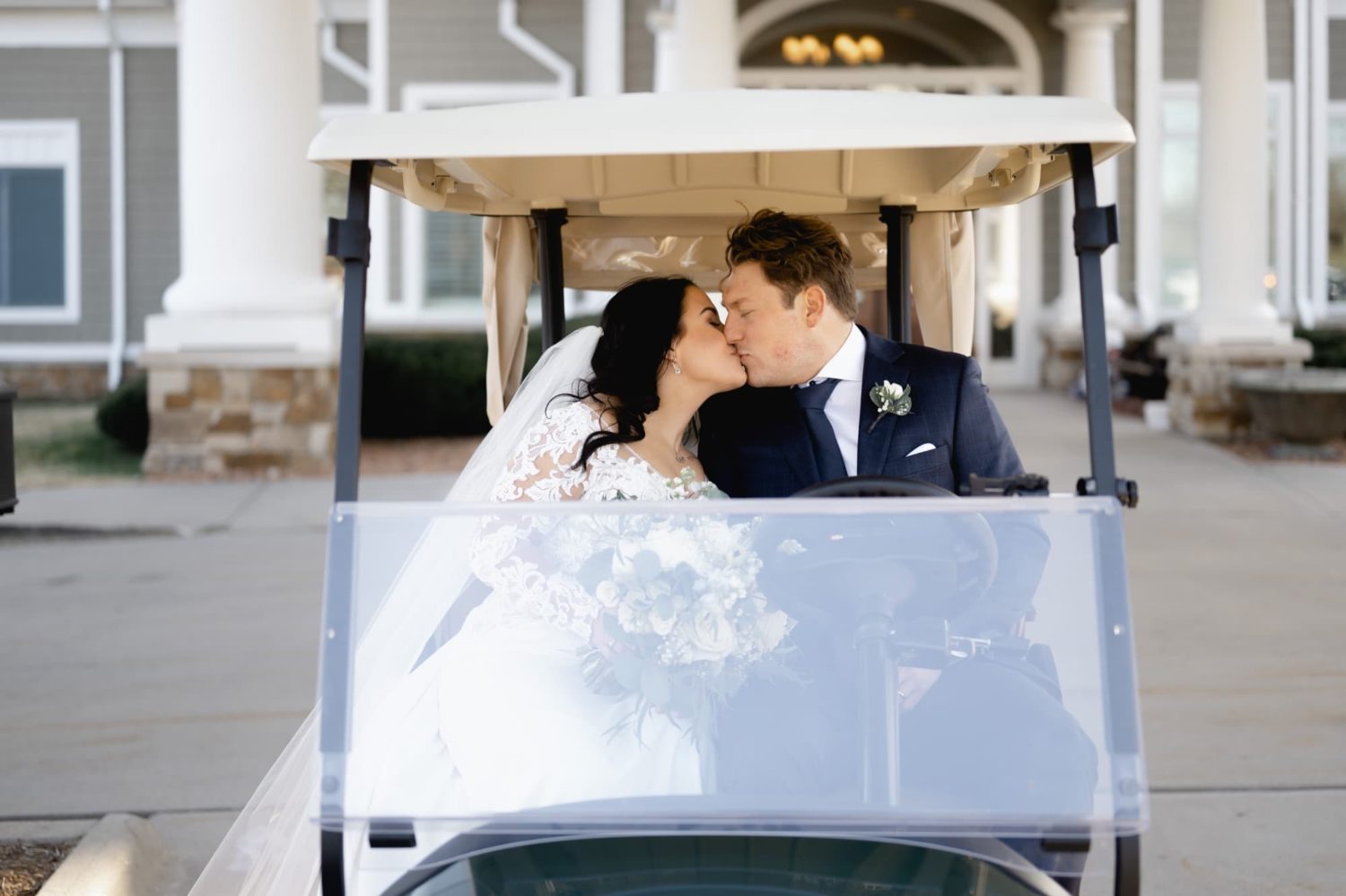 Brighton groom kissing in custom golf cart at Glen Oaks country club