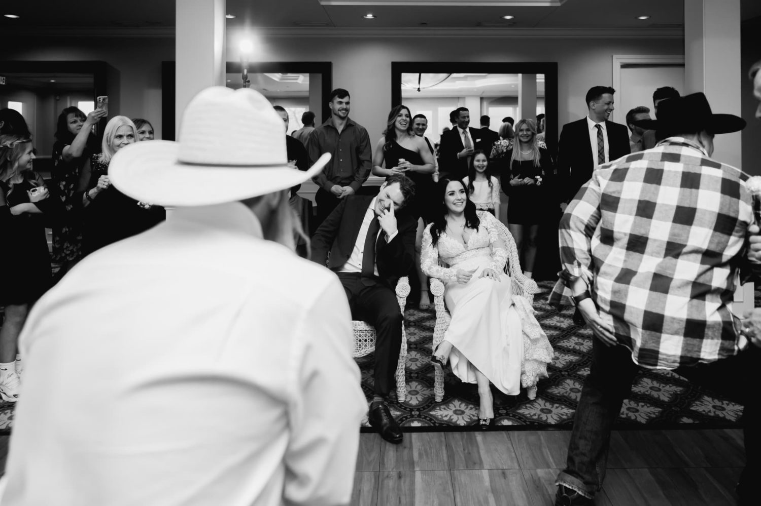 Bride and groom laughing at family dancing in a wedding reception at Glen Oaks country club