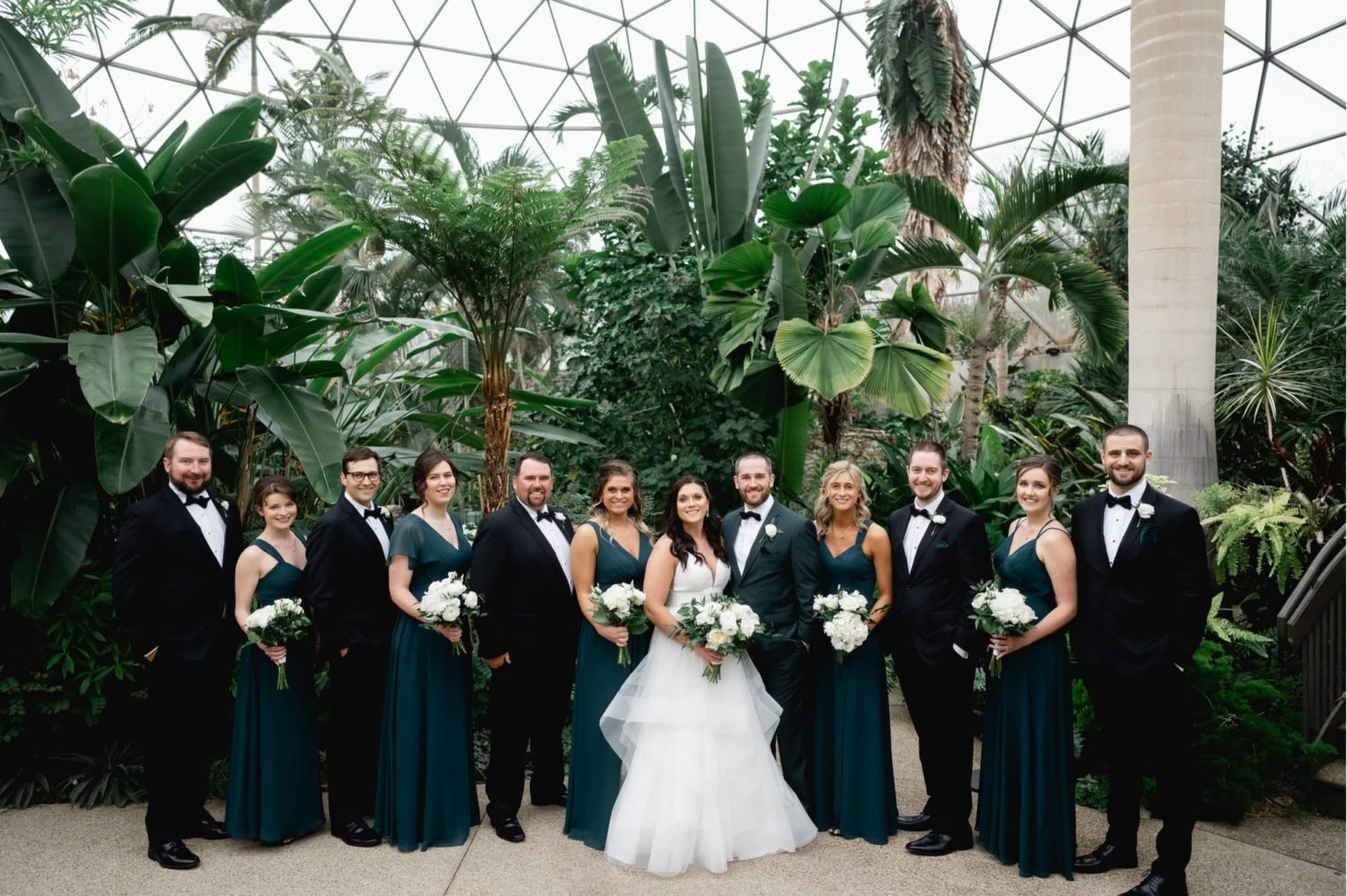 Wedding party standing in front of the beautiful Des Moines botanical Garden