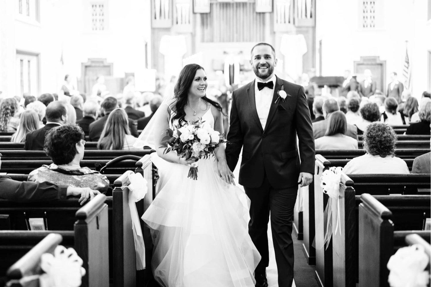 Bride and groom smiling walking out of the church after they have been married