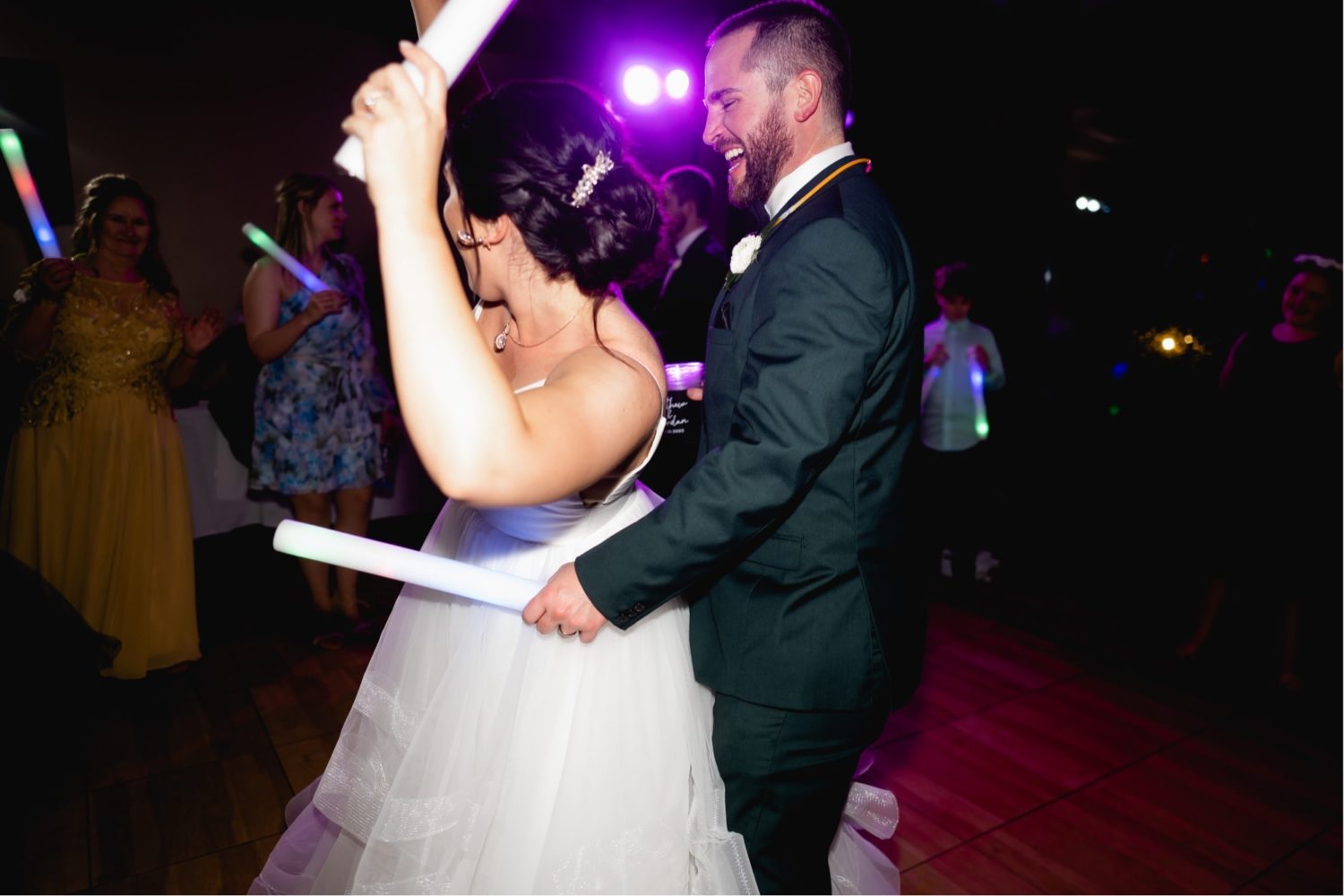 Bride and groom on the dance floor with glow in the dark sticks