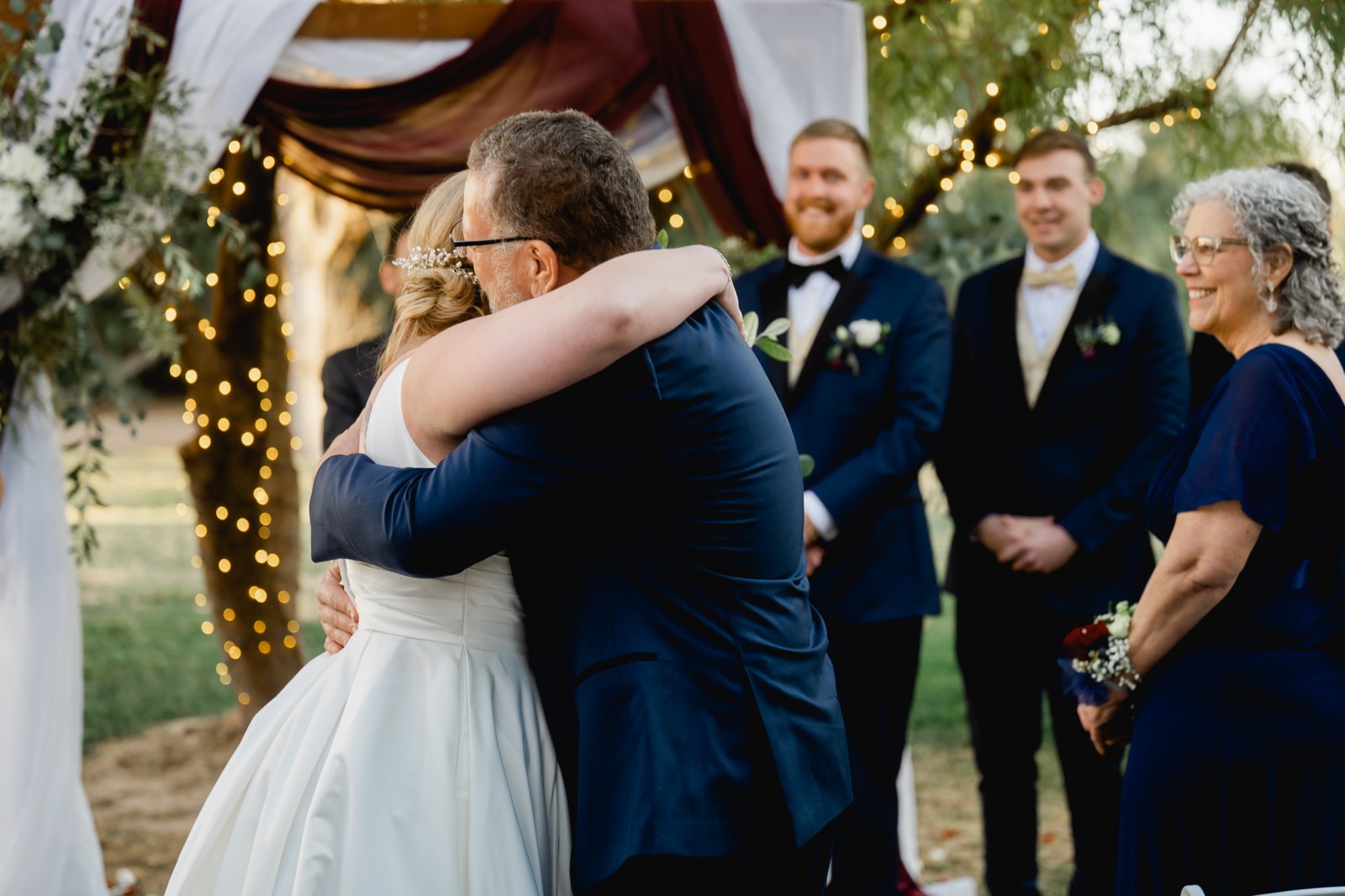 Father hugging his daughter at the end of the aisle
