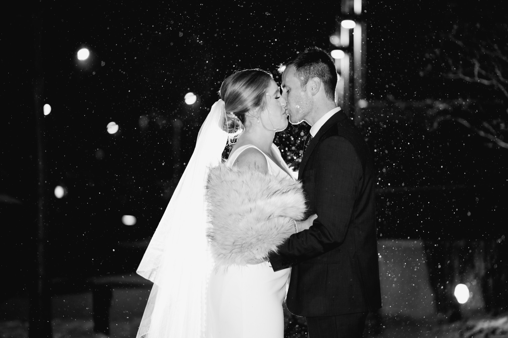 bride and groom kissing at night in snow