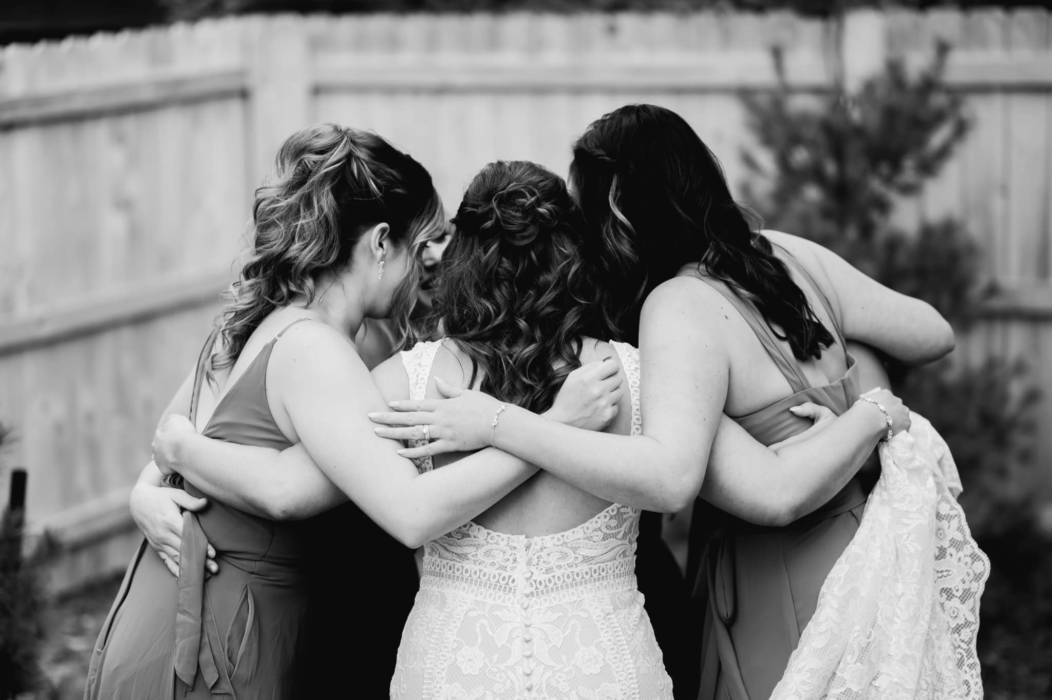 bride and bridesmaids hugging