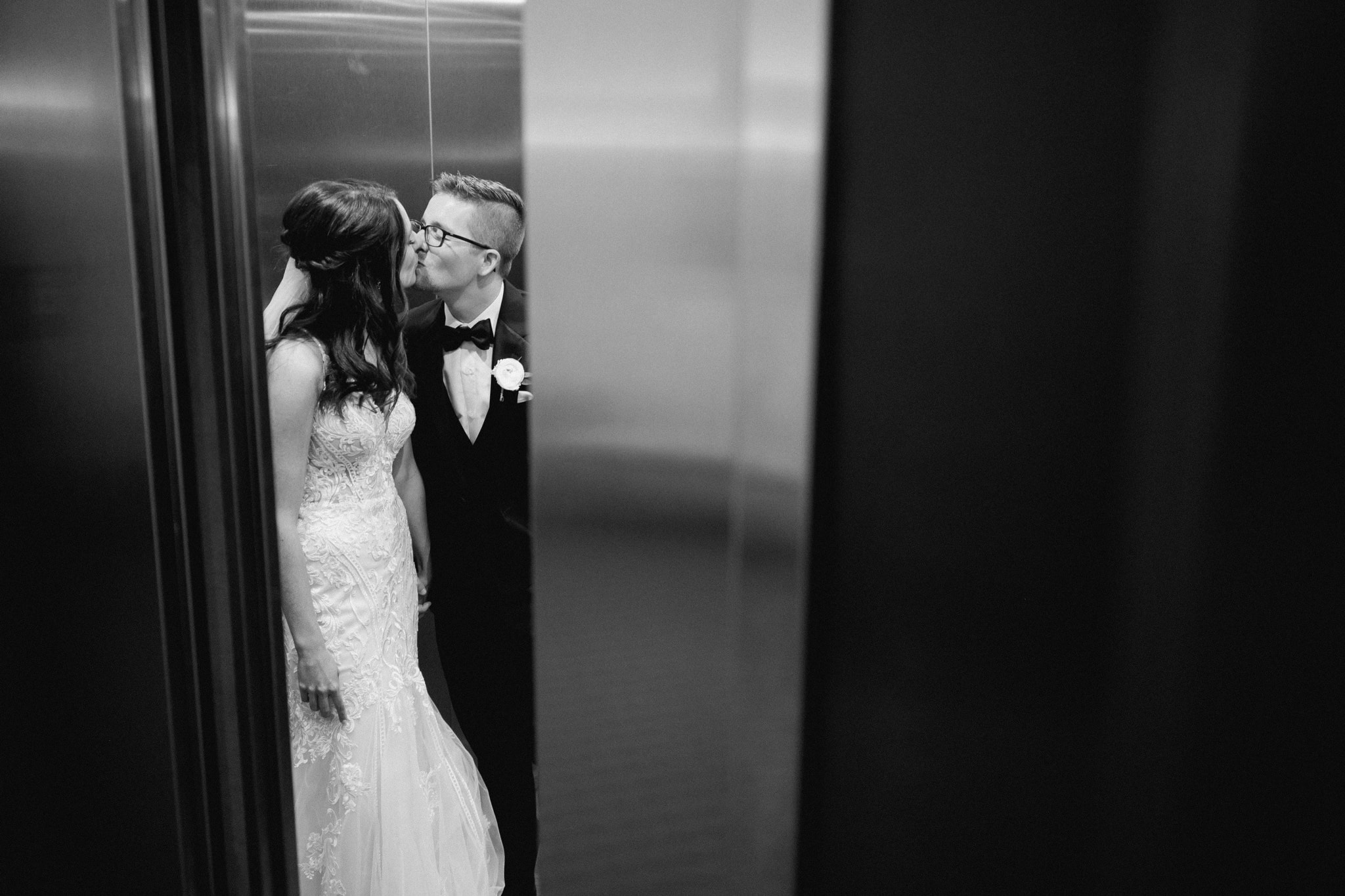 bride and groom kissing in an elevator