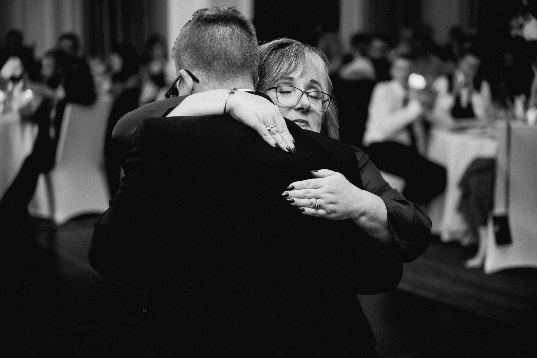 mother hugging son at wedding