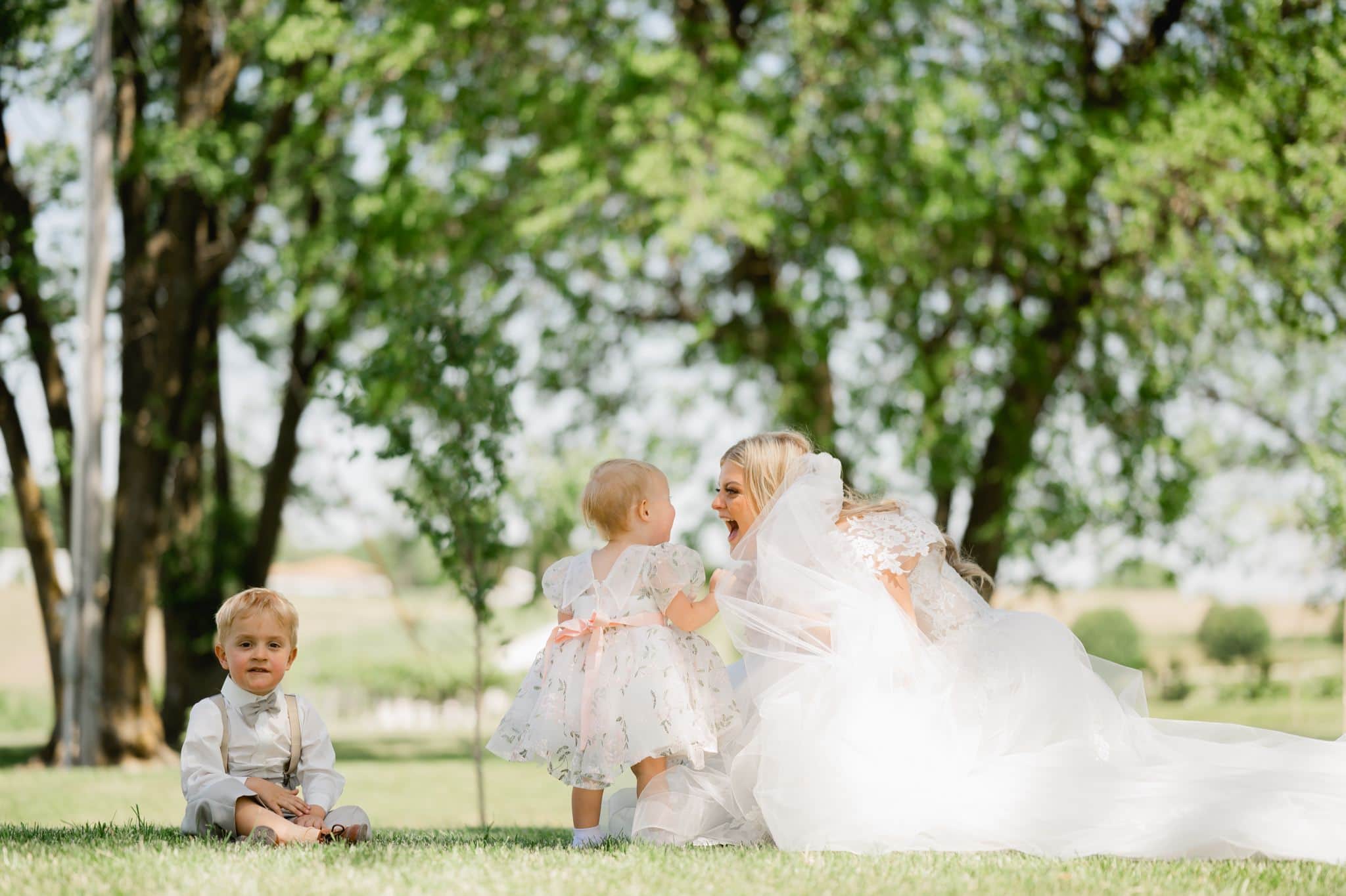bride laughing with flower girl and ring bearer