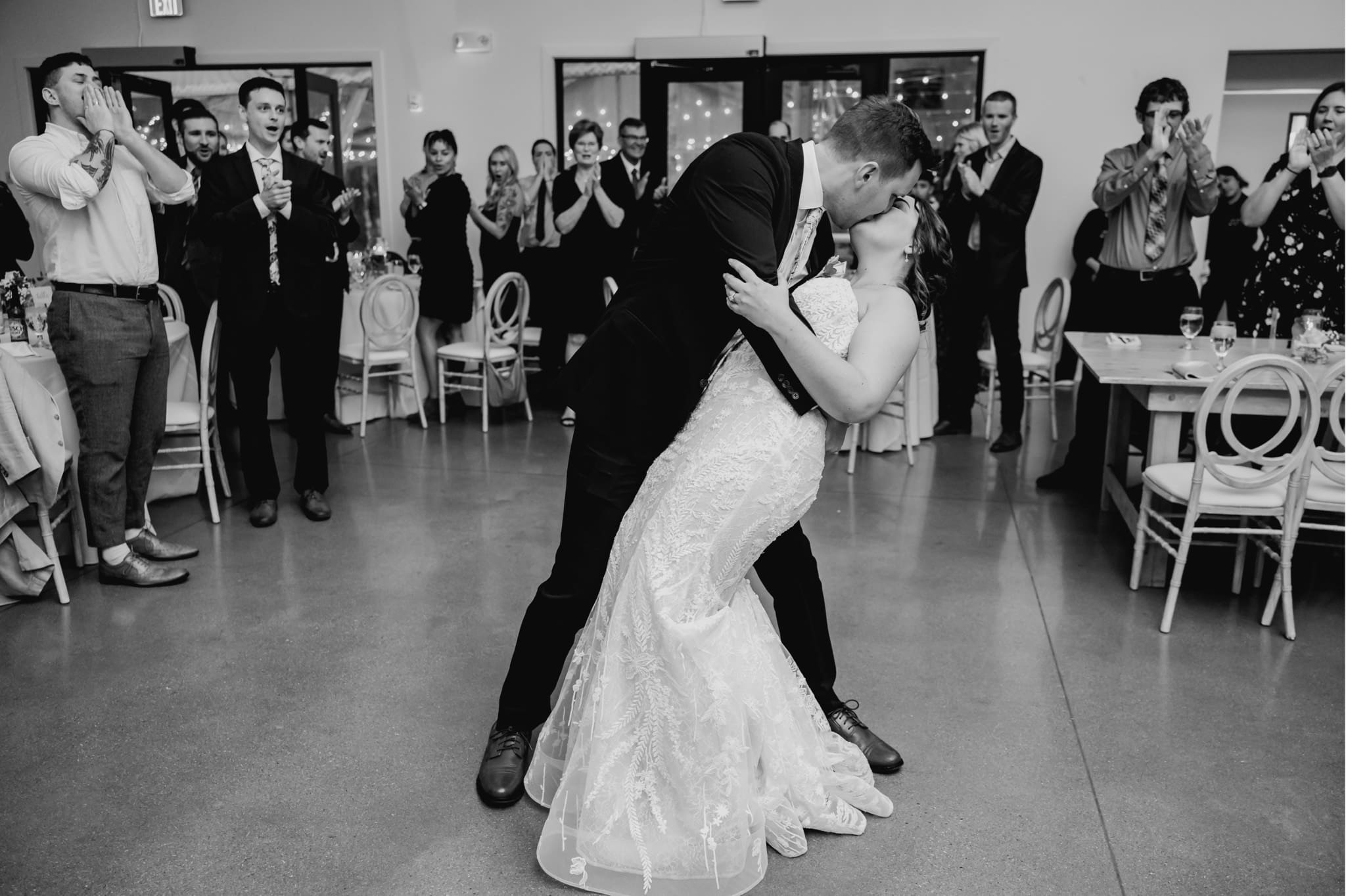 groom dipping bride for a kiss at reception
