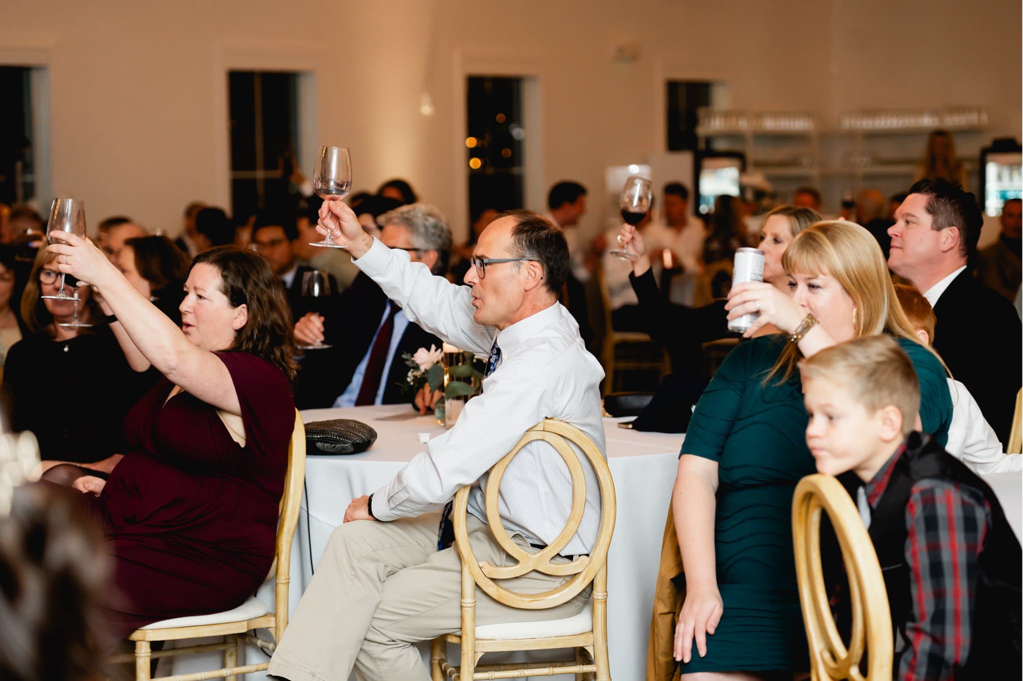 guests raising glasses during wedding toast