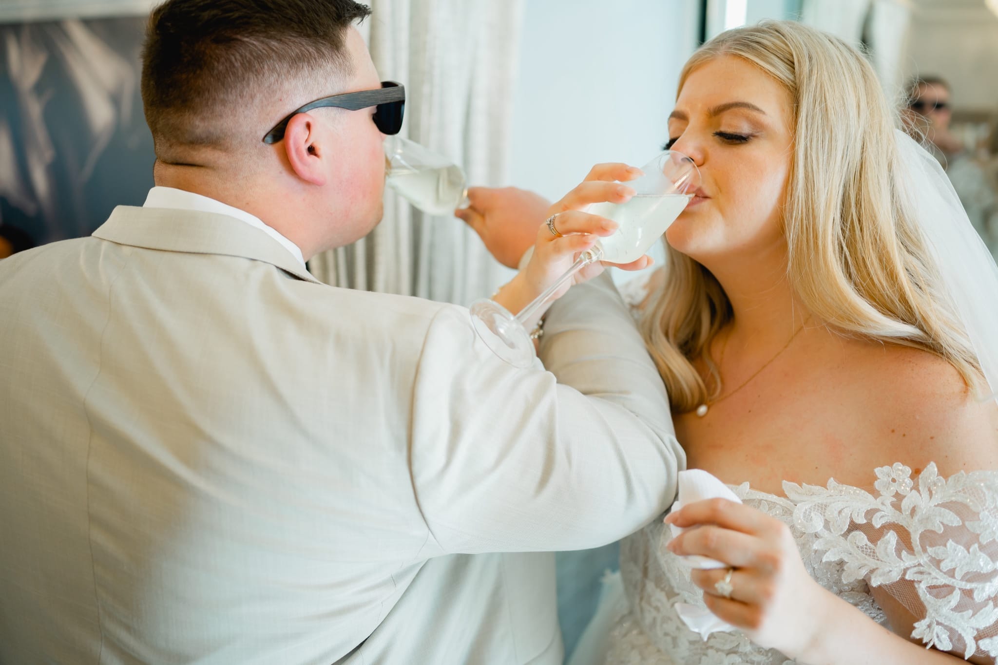 bride and groom drinking champagne